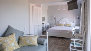 Un dormitorio con cama, sofá, escritorio y silla.