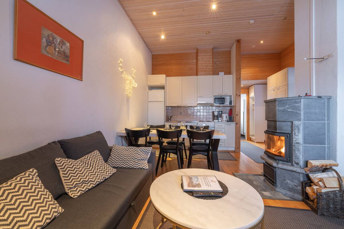 Una sala de estar moderna con un sofá, una mesa de centro, chimenea y un comedor con sillas y una mesa.
