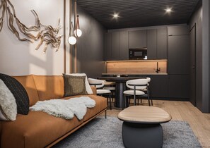 Un salon moderne comprenant un canapé, une table basse et un coin repas avec des chaises et une table.