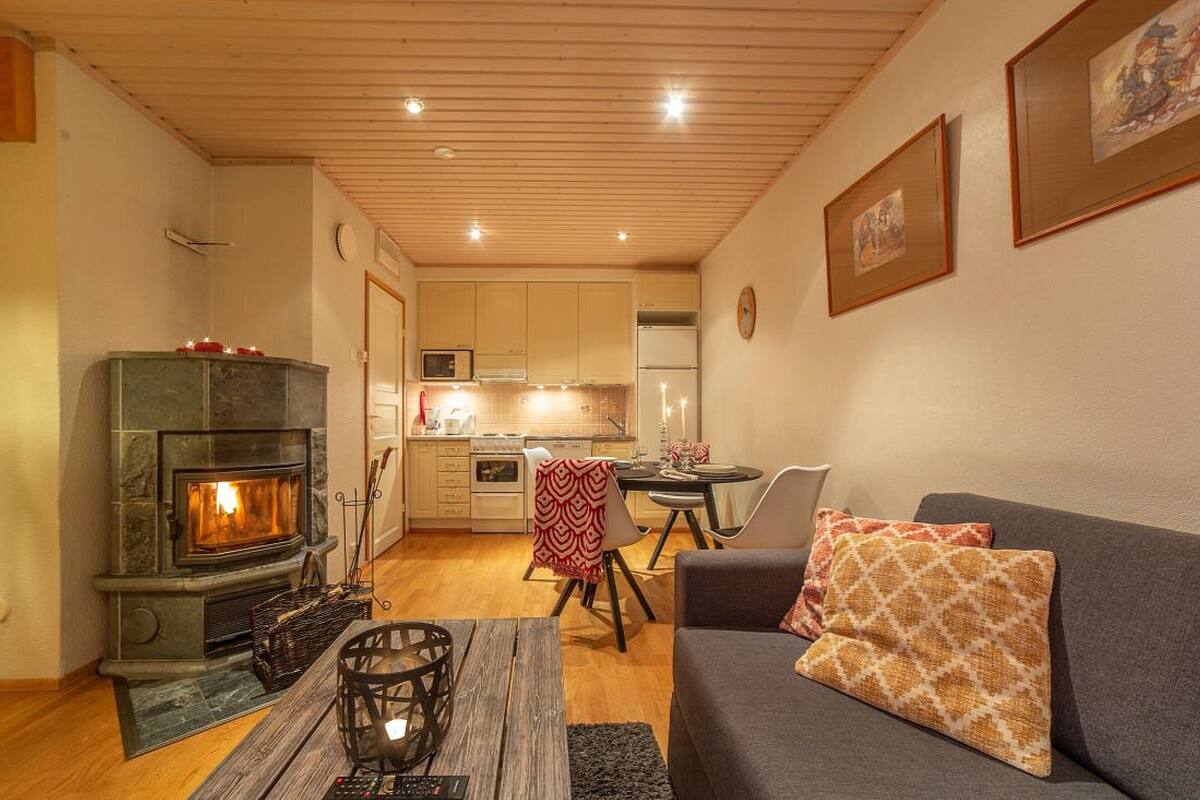 Una sala de estar acogedora con chimenea, comedor y cocina.