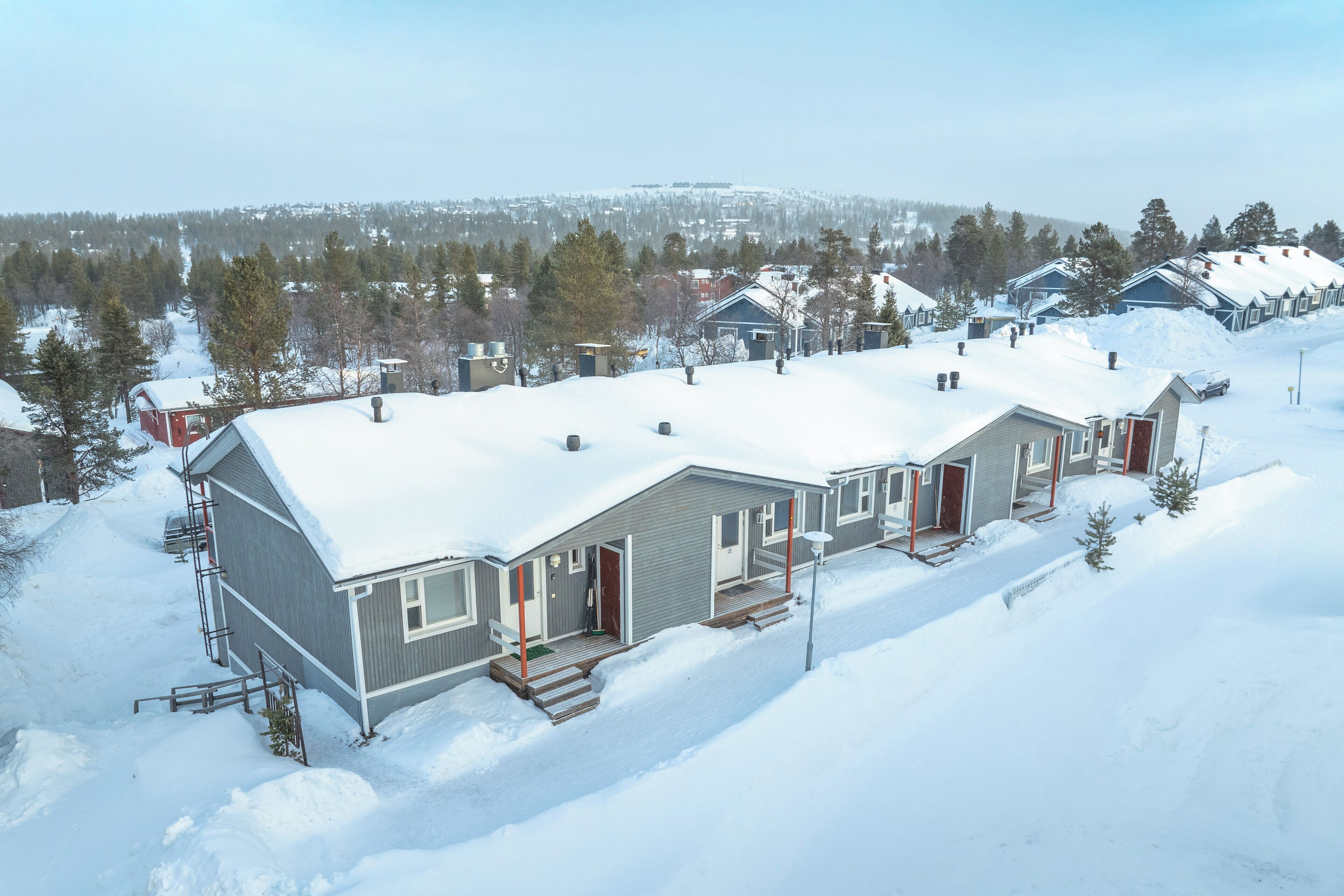 Un barrio residencial cubierto de nieve, con varias casas, cada una con un estilo arquitectónico diferente.