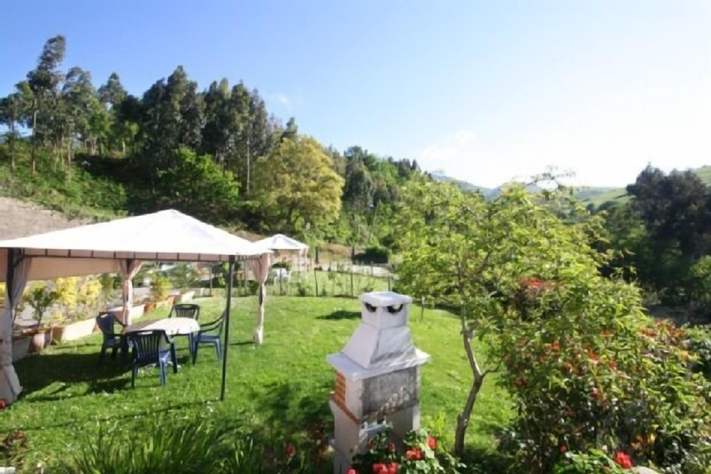 A garden with a gazebo, outdoor seating, and a decorative owl statue.