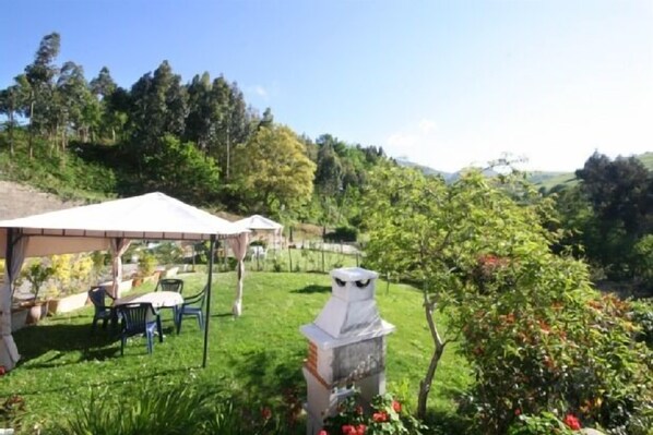 A garden with a gazebo, outdoor seating, and a decorative owl statue.