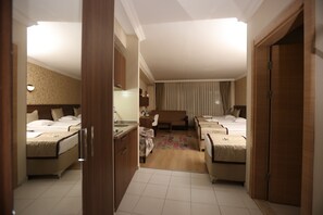 Una habitación de hotel con dos camas, un escritorio, una silla, un sofá y un baño.