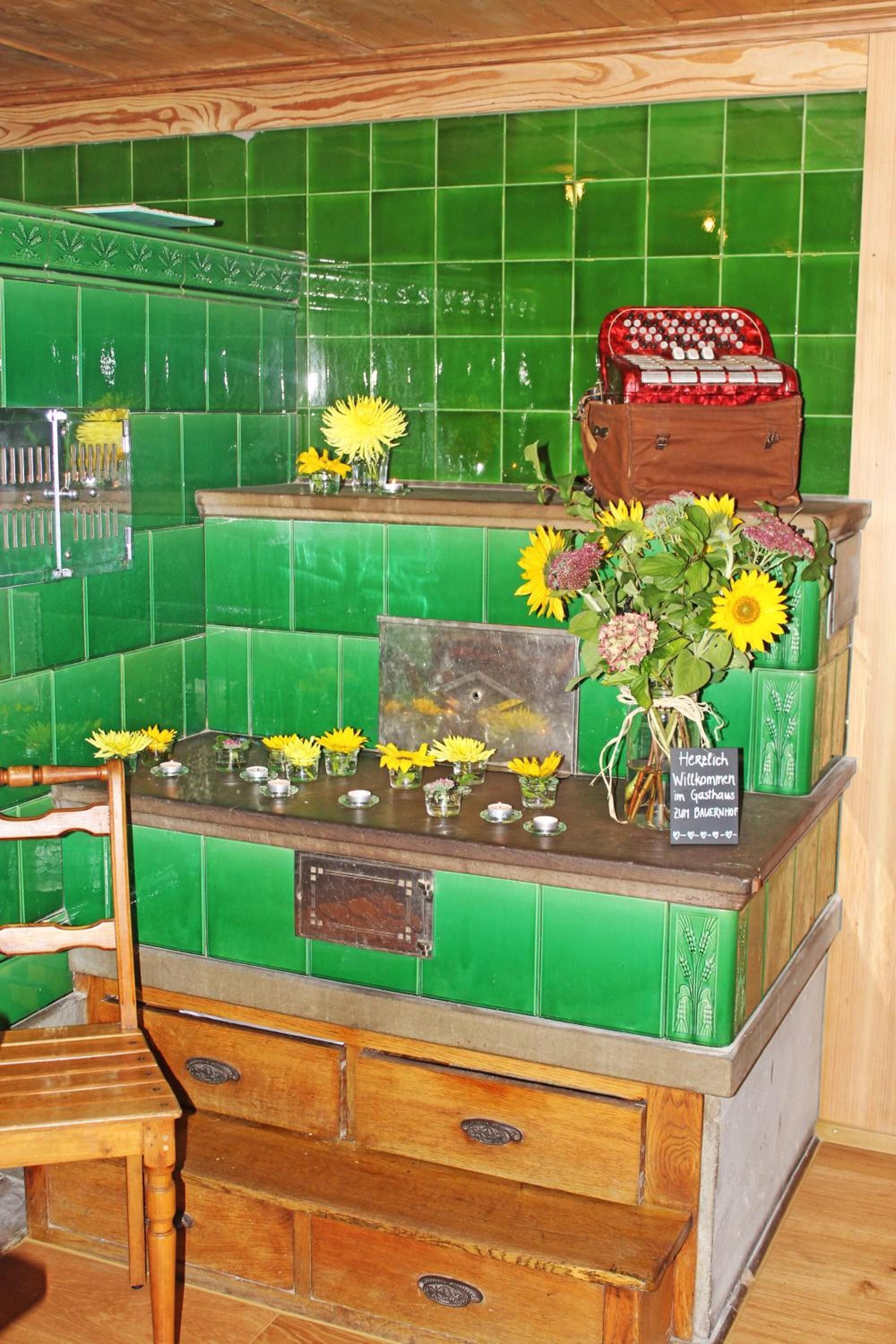 A reception area with a green tiled wall, a wooden counter, and a sign welcoming guests.