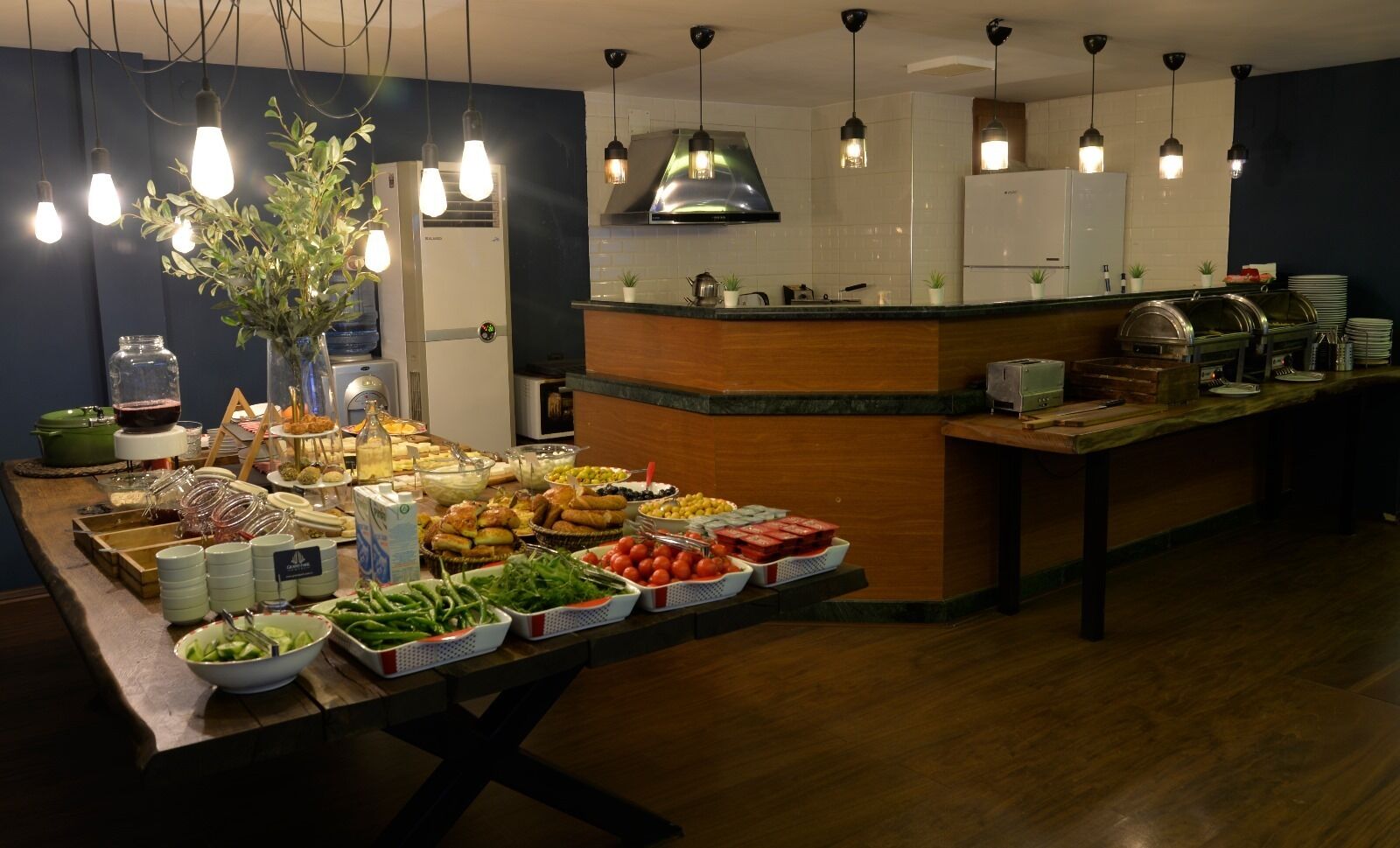 Una mesa de buffet con diferentes alimentos y una cocina al fondo.