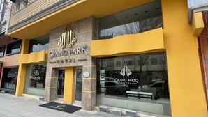 L’extérieur du Grand Park Hotel, avec sa façade jaune et ses grandes fenêtres.