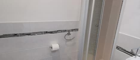 A modern bathroom with a toilet, sink, and shower area.
