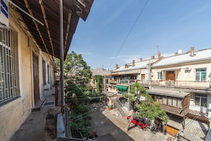 A residential area with multi-story buildings, a visible staircase, and a red car parked on the street. - Apartment Alla (Odesa)