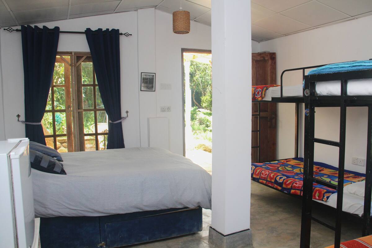 A room with a single bed, a bunk bed, and a small table.