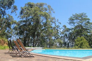 Alberca al aire libre y camastros 