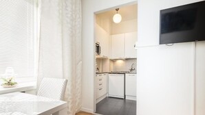 A modern kitchen with white cabinets, a microwave, and a dishwasher. - Go Happy Home Apt Vuorimiehenkatu 14 (Helsinki)