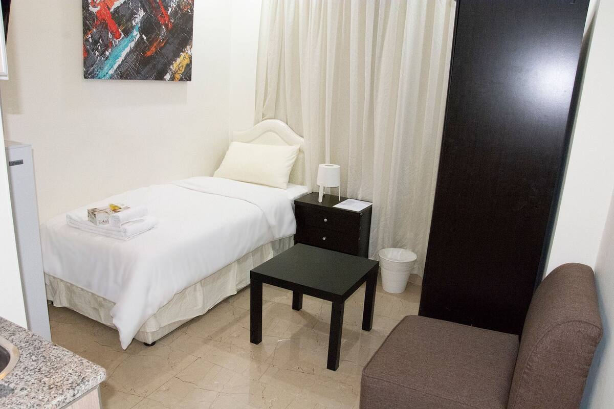 A neatly arranged bedroom with a bed, bedside table, and a small table.