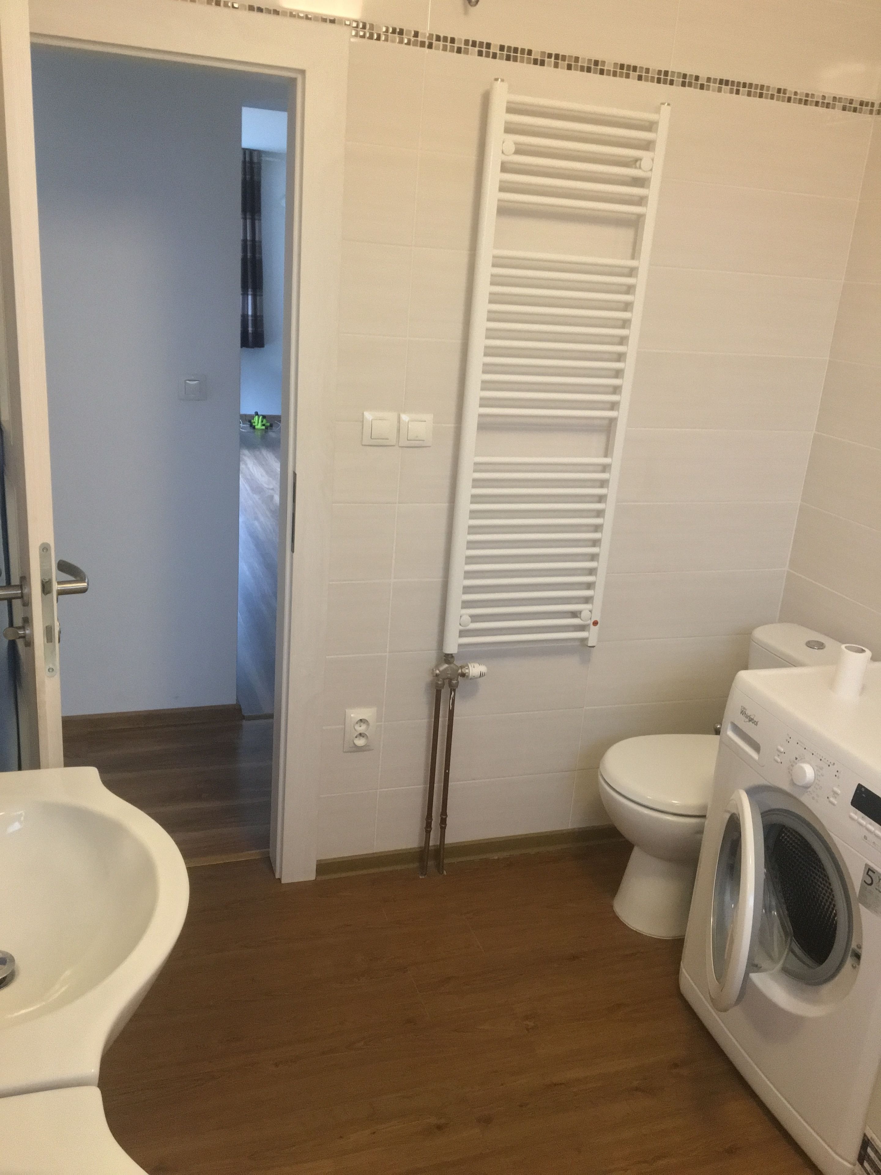 A bathroom with a toilet, a washing machine, and a bidet.