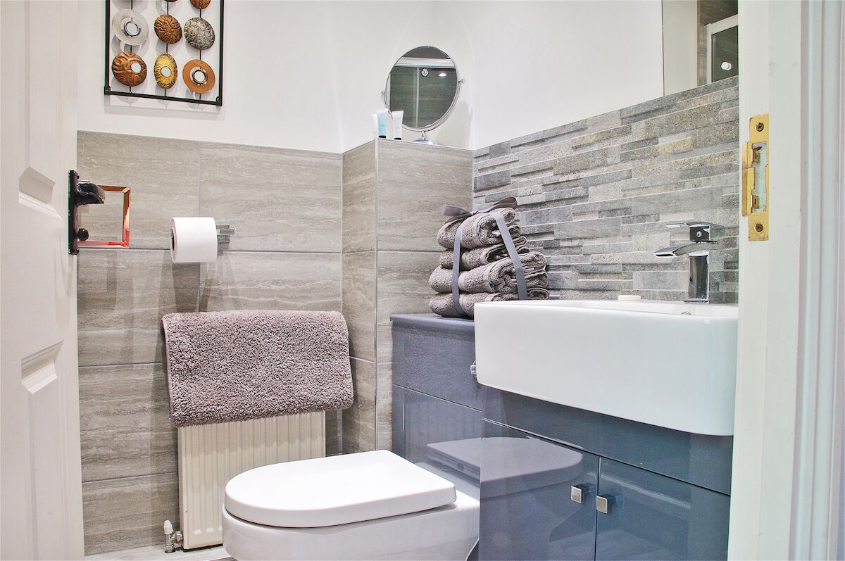 A modern bathroom with a toilet, sink, and towel rack.