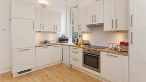 Una cocina moderna con armarios blancos, microondas, tostadora y estufa.
