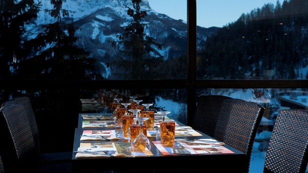 Mesa lista para comer con vista a la montaña a través de amplios ventanales.