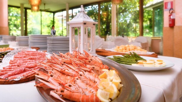 Een buffet met zeevruchten, waaronder garnalen, asperges en kaas.