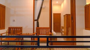 Una habitació amb taula i cadires de fusta, una porta que condueix a un altre espai, i un petit armari.