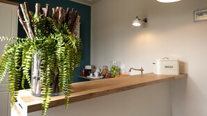 A kitchen counter with a coffee maker, a bread box, and a plant. - La Locanda di Corrado (Cerreto Guidi)