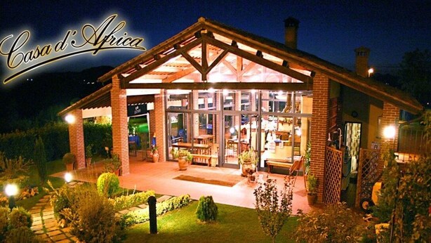 A well-lit, spacious building with a covered patio area, large windows, and a brick exterior. - La Locanda di Corrado (Cerreto Guidi)