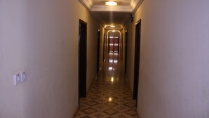 Un pasillo estrecho con piso estampado, paredes blancas y puertas a ambos lados.