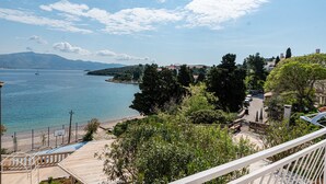 Une vue sur la côte, avec un ciel dégagé, une plage et une zone résidentielle avec des maisons et des arbres.