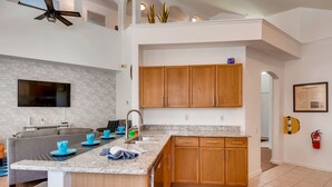 Eine moderne Küche mit Granit-Arbeitsplatten, Holzschränken und einem eingebauten Backofen.
