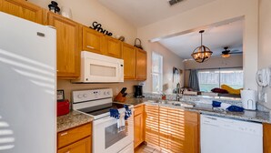 A kitchen with wooden cabinets, a white refrigerator, a microwave, an oven, and a dishwasher. - 4BR Home in Regal Palms by FS FL VH-844 (Davenport)