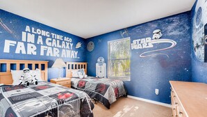 A Star Wars-themed bedroom with two beds, a dresser, and a wall mural. - 4BR Home in Regal Palms by FS FL VH-844 (Davenport)