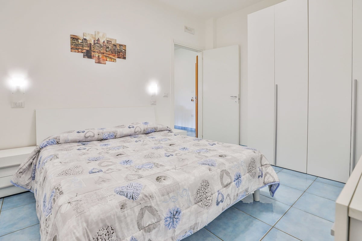 A bedroom with a bed, a wardrobe, and a door.