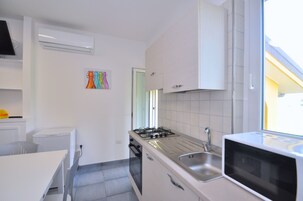 Apartamento, 1 quarto | Cozinha americana privada | Geladeira, micro-ondas, fogão, cooktop
