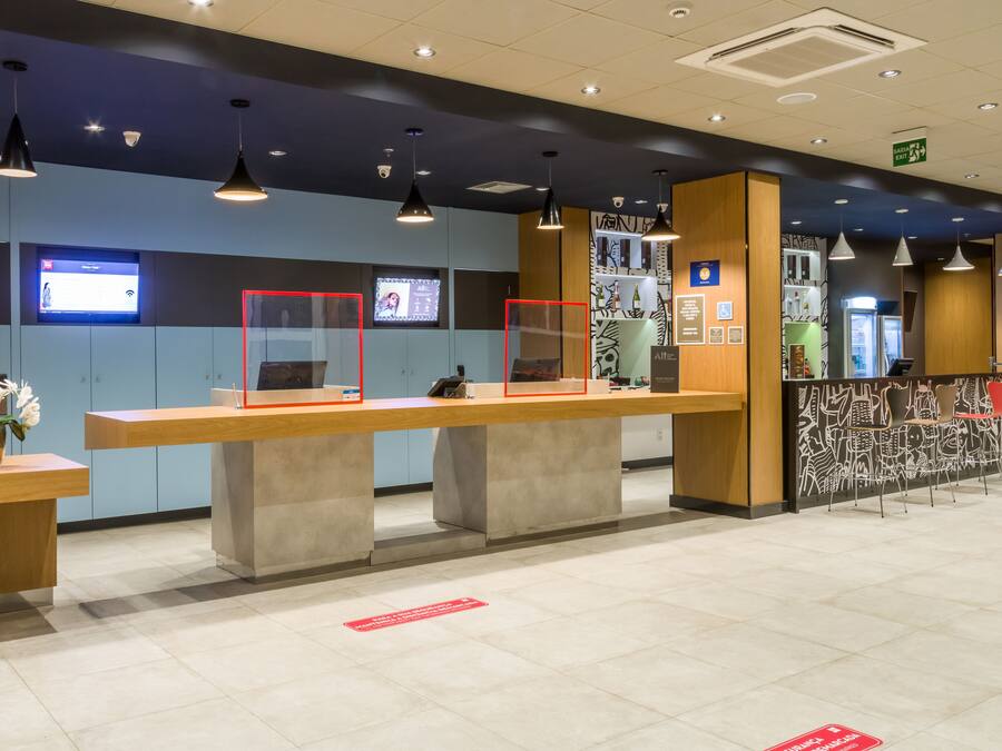 A reception area with a counter, seating, and a wall-mounted screen.