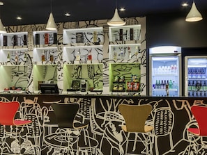 A bar area with shelves of liquor, a coffee machine, and seating with chairs and tables. - ibis Americana (Americana)