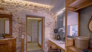 Een kamer met een stenen muur, een houten bureau en een spiegel.