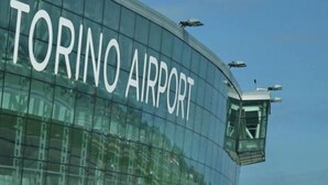 Un edificio moderno con el texto "TORINO AIRPORT" en su fachada.
