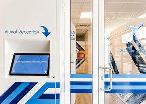 Un área de recepción virtual con pantalla táctil y una flecha direccional.