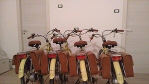 Una hilera de bicicletas antiguas con asientos de cuero marrón y guardabarros amarillos, estacionadas en el interior.