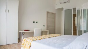 Una habitación de hotel con cama, escritorio y armario.
