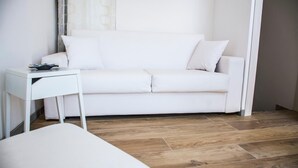 Un sofá blanco con una mesita auxiliar en una habitación con suelo de madera.