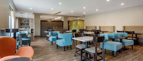A modern hotel lobby with seating areas, a reception desk, and a decorative wall.