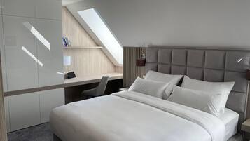 Una habitación de hotel moderna con una cama grande, un escritorio y un tragaluz.