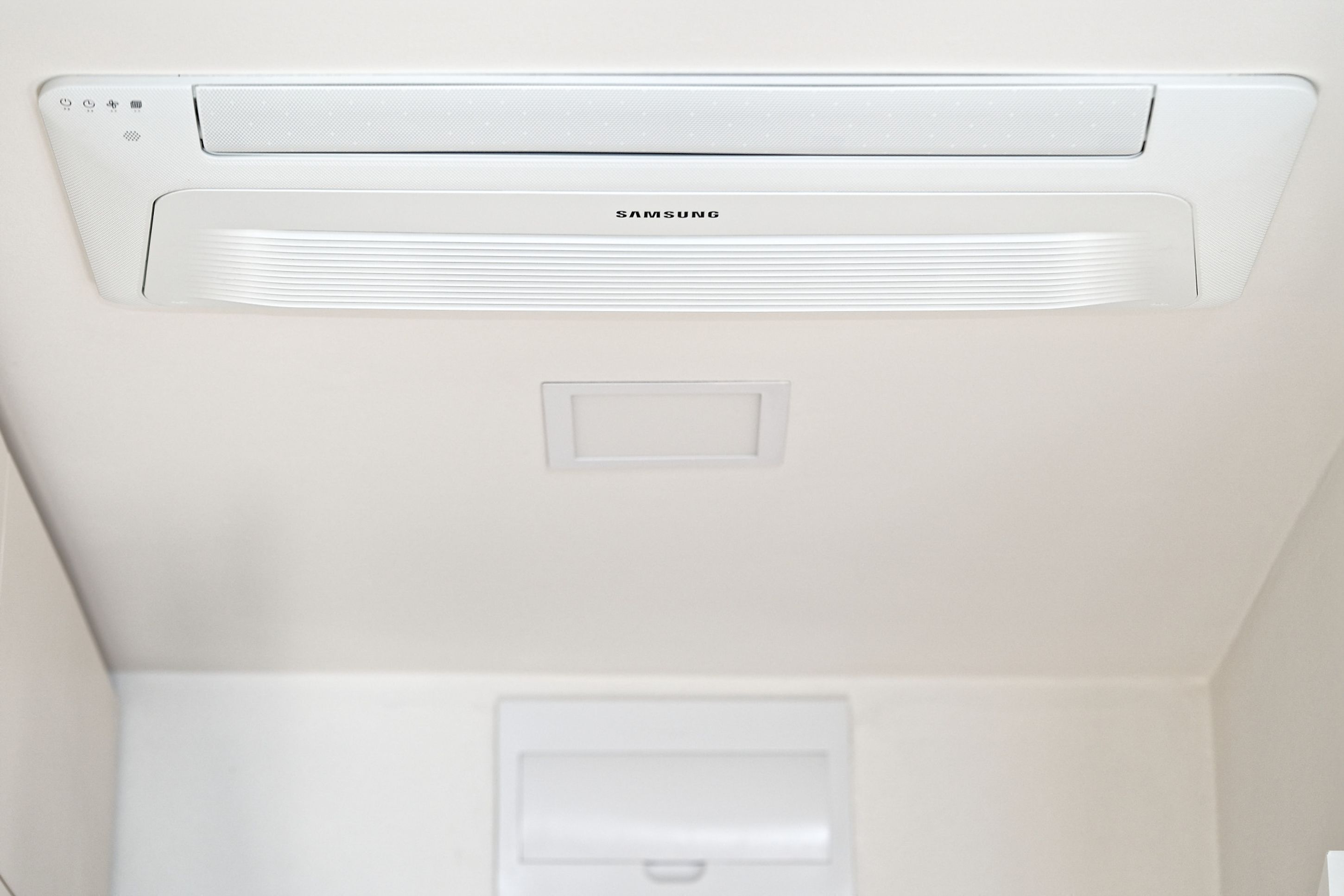 Een wit plafond met een Samsung airconditioner en een inbouwverlichting.
