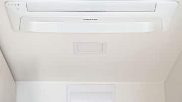 Teto branco com unidade de ar condicionado Samsung e luminária embutida.