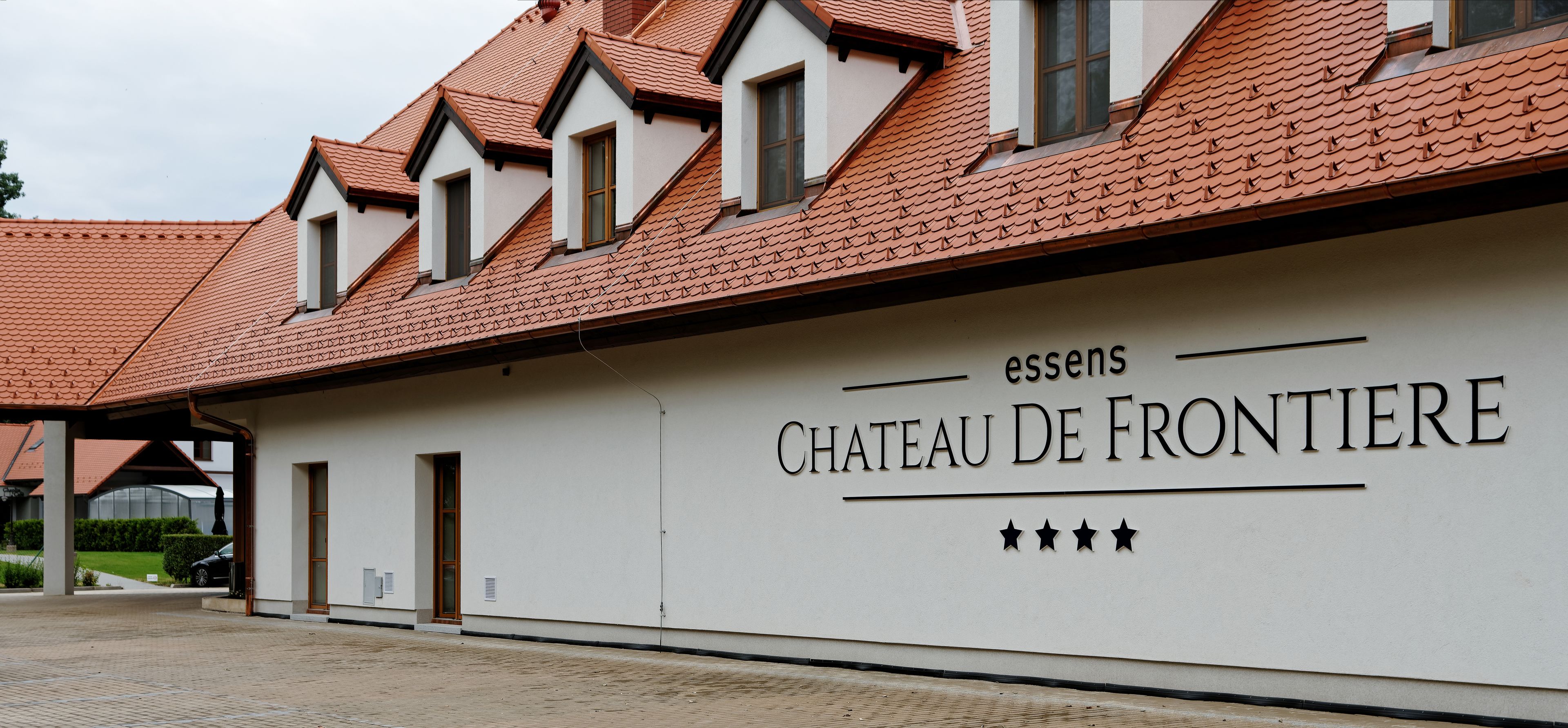 A building with a sign reading "CHATEAU DE FRONTIERE" and a series of windows.