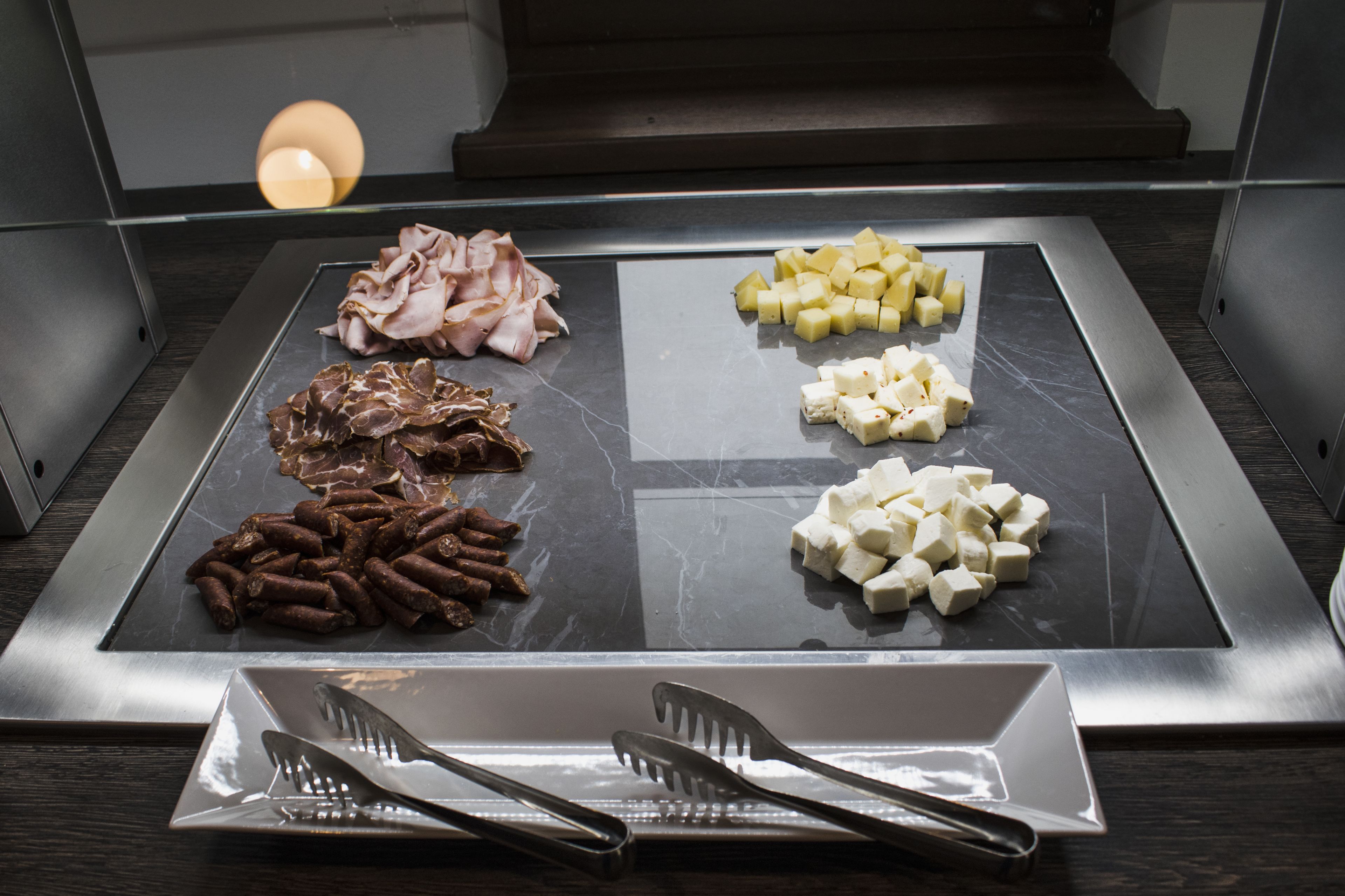 Una parrilla con diferentes carnes y quesos.