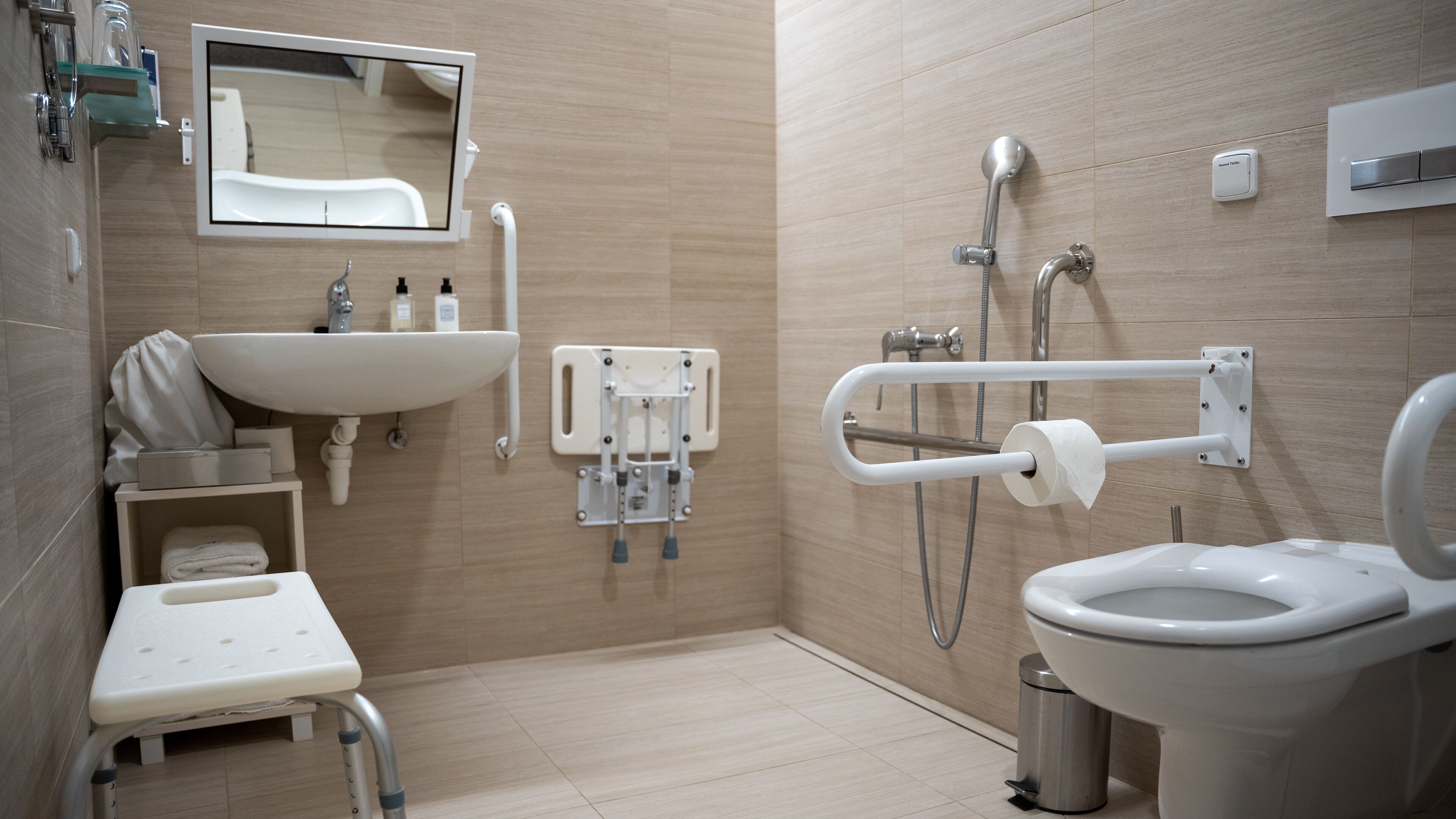 Een moderne badkamer met een wastafel, toilet en douche.