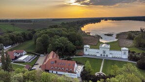 A large estate with a prominent building, a lake, and surrounding greenery. - Hraniční zámeček (Lednice)