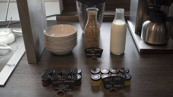 A table with various jars of honey and a bottle of milk.
