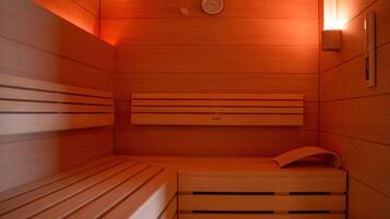 A sauna with wooden benches and a wall-mounted heater.